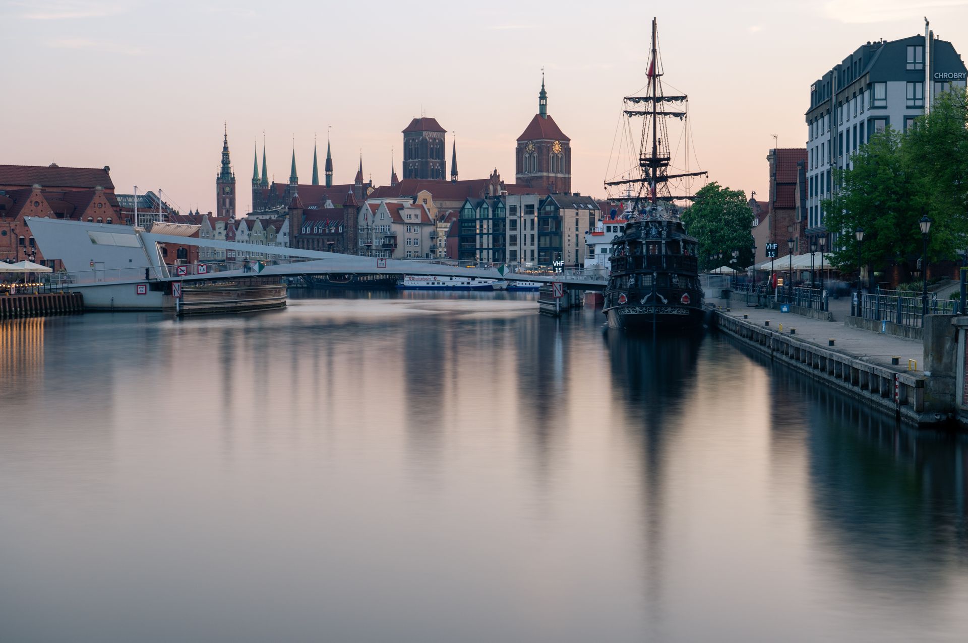 The Motlawa waterfront in Gdansk with the historic Old Town skyline at dusk