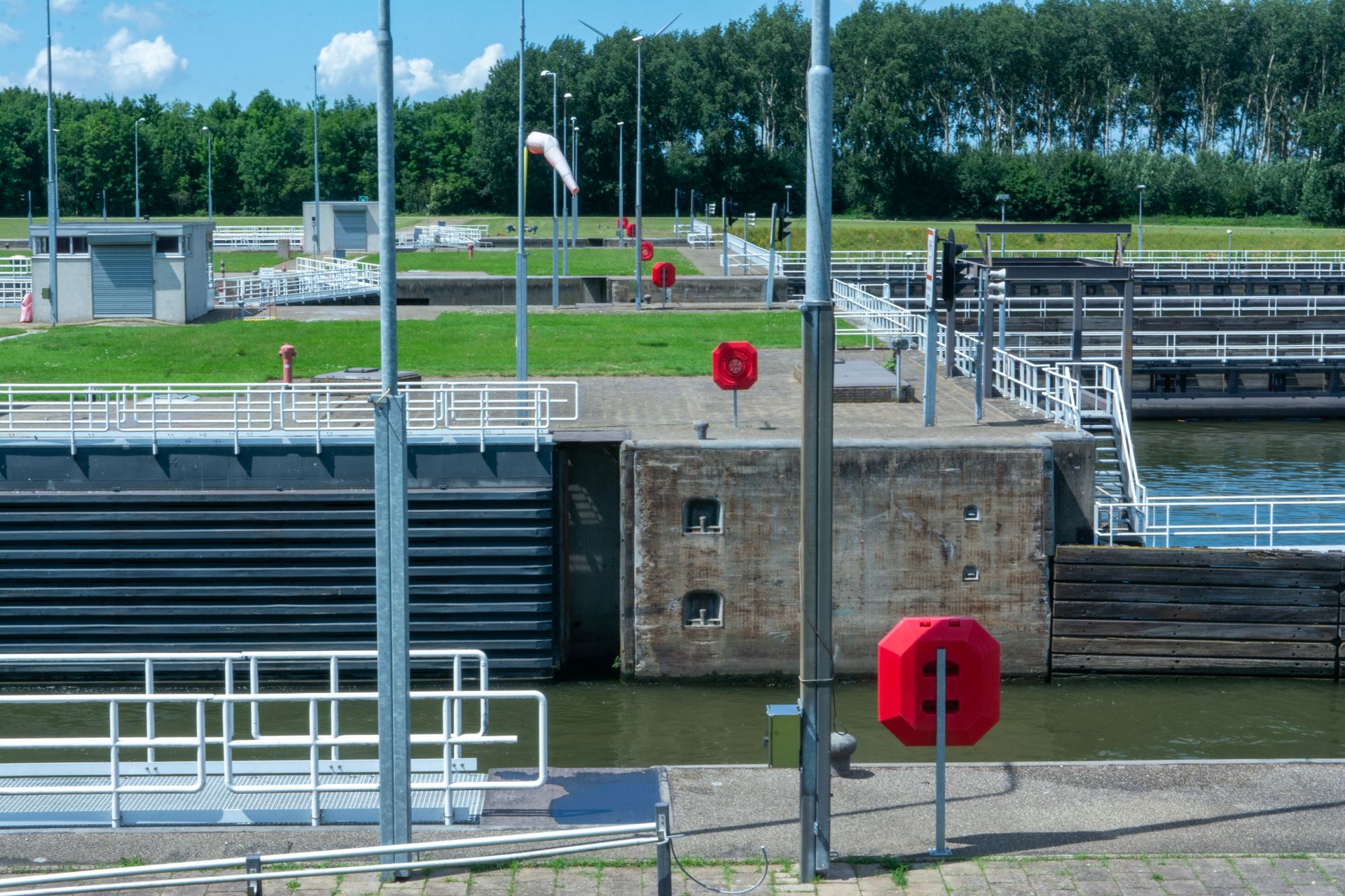 Nowoczesna śluza z awanportem, sygnalizacją świetlną, rękawem wiatrowym i kołami ratunkowymi na nabrzeżu